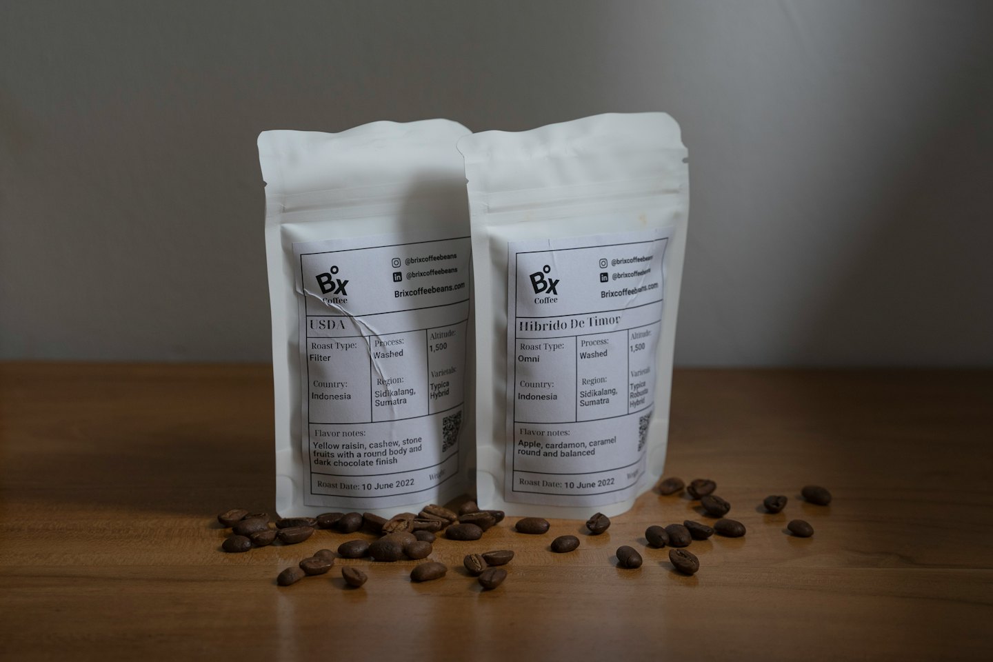 Zwei weiße Kaffeepäckchen stehen auf Holz.